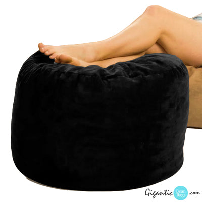 Our black bean bag ottoman with legs resting on them.