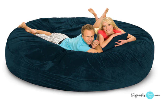 Our 8 ft gigantic bean bag bed in Navy Blue with a couple resting on it.