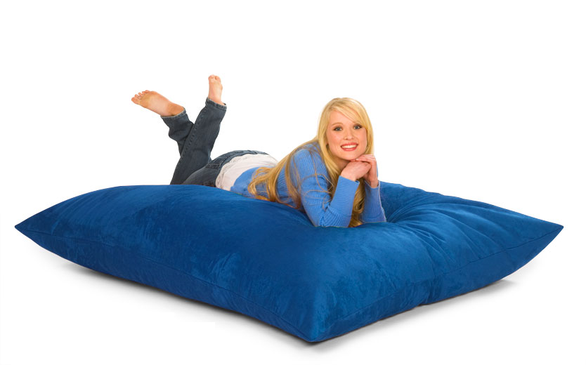 Girl resting on a blue 6 ft Bean Bag Pillow with a white background.