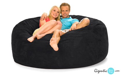 The 6 ft. black bean bag chair with a happy couple sitting on it with a white background.