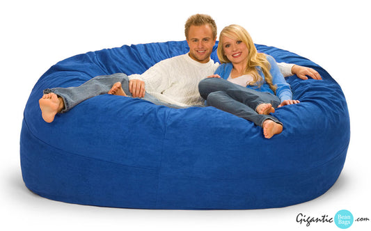 This image shows a blue bean bag in the 7 ft  x 7 ft model. There's a cozy couple on the bean bag. The image has a white background and the company logo on the bottom right.