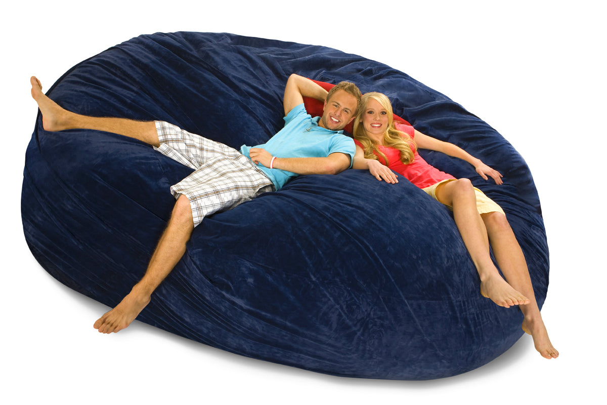 An 8 ft Navy Blue Bean Bag Bed with our 2 models reclining on it.