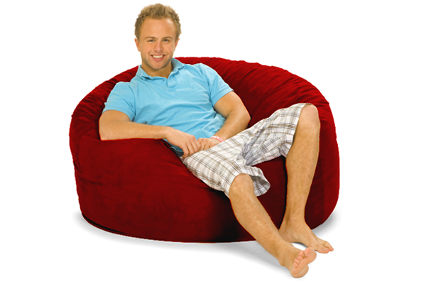 A happy man sitting on a red bean bag chair.