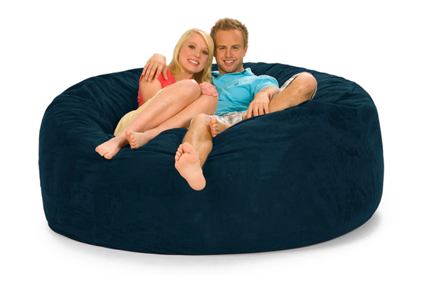 A cozy happy couple lounging on a navy blue bean bag sofa