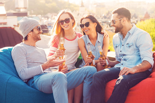 Four adults relaxing and talking on giant bean bags.