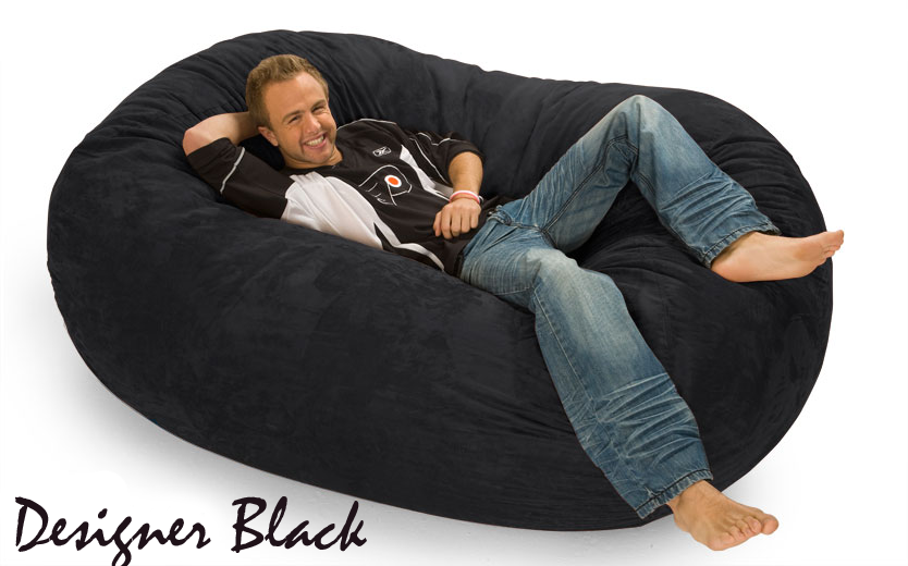 6 ft. Oval Bean Bag Lounger with a man relaxing on it with the words "Designer Black" on the bottom left.